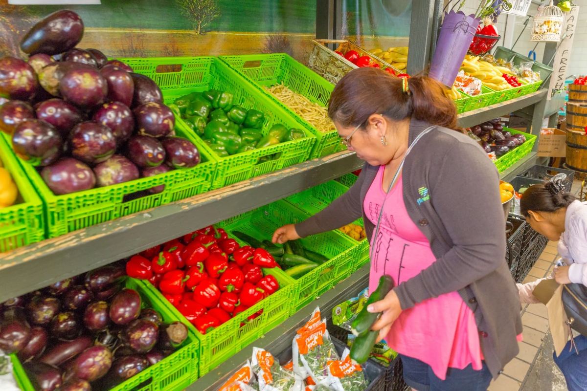 A woman is looking at vegetables in the produce section.