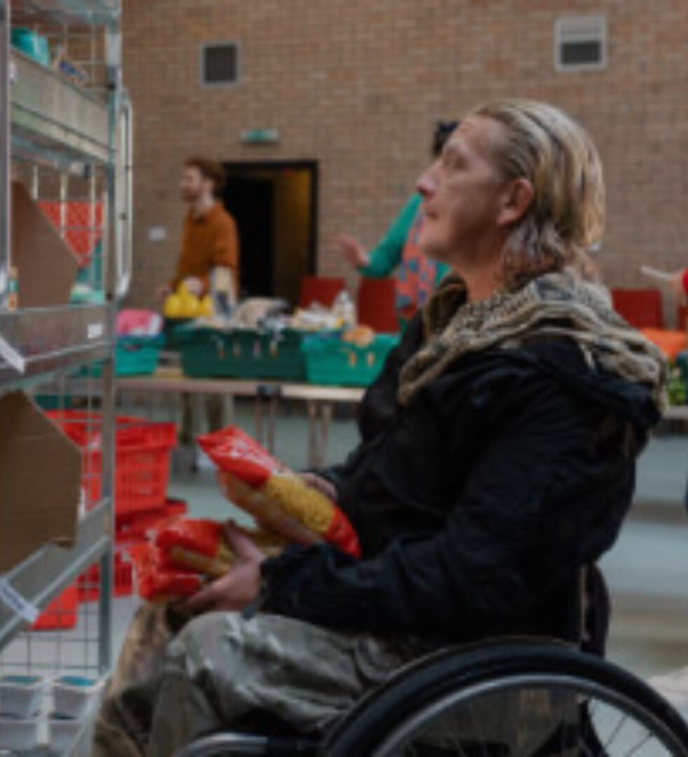 A woman in a wheelchair holding food.