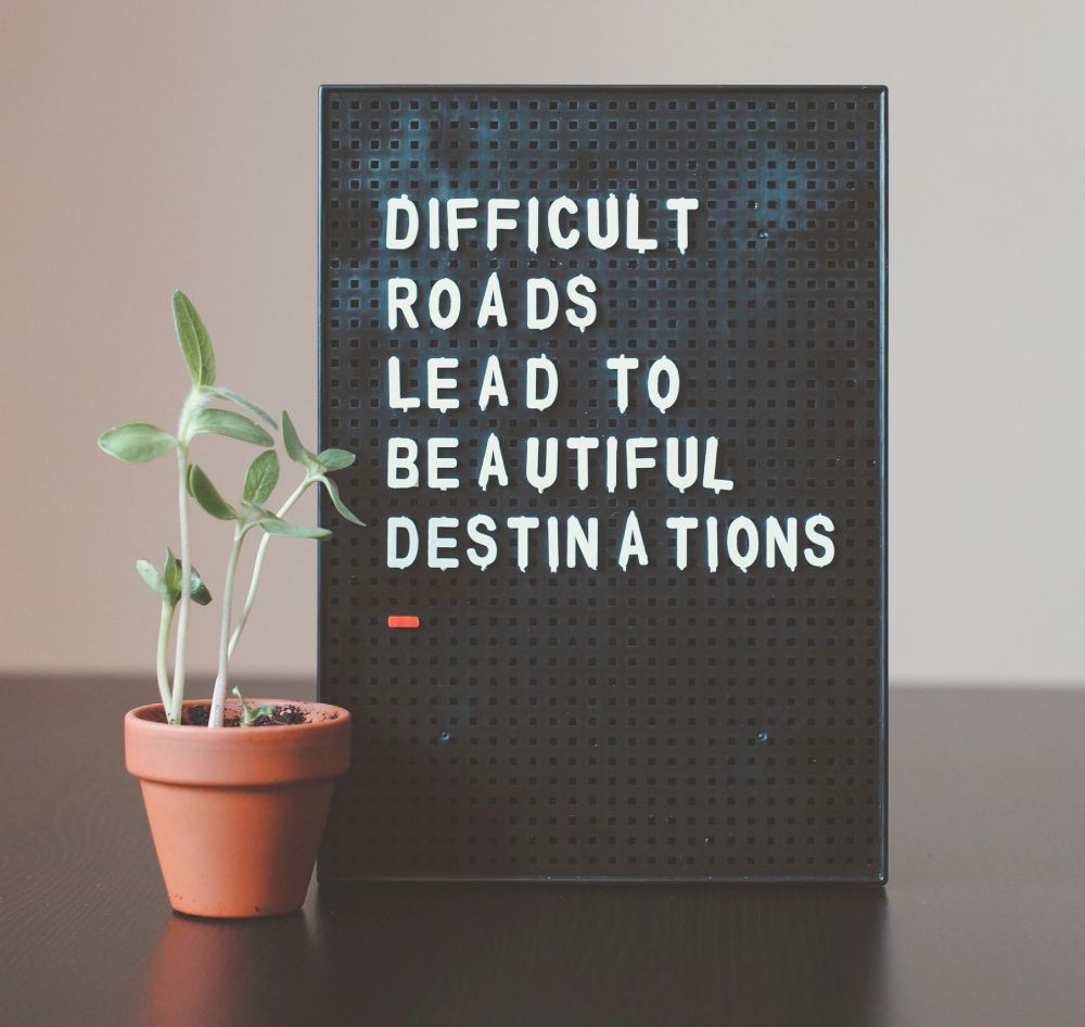 A sign that says difficult roads lead to beautiful destinations.