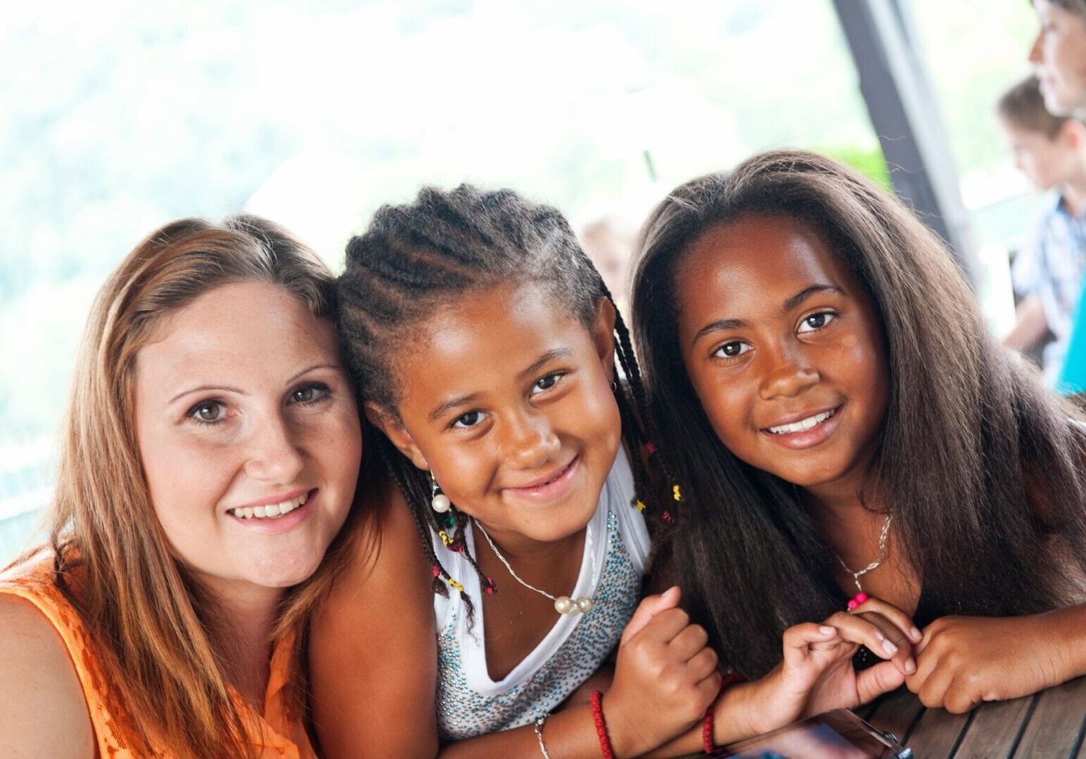 Three young girls posing for a picture with their mom.